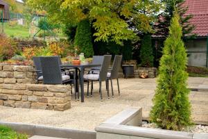 a patio with a table and chairs in a garden at Villa Gallera - Slovak Paradise in Dravce