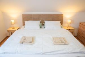 a bedroom with a large white bed with two lamps at Villa Gallera - Slovak Paradise in Dravce