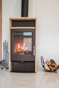 a television with a fireplace in a living room at Villa Gallera - Slovak Paradise in Dravce