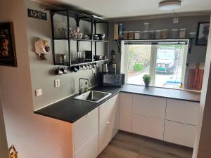 a kitchen with white cabinets and a sink and a window at Trolladalen-Sogndal in Sogndal +2 photos