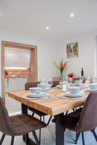 a wooden table with chairs and plates and wine glasses at Villa Gallera - Slovak Paradise in Dravce +55 photos