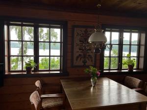 a dining room with a wooden table and windows at Lommen in Dals Långed