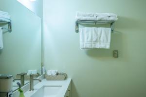 a bathroom with a sink and a mirror and towels at Bouctouche Bay Inn in Bouctouche +62 photos