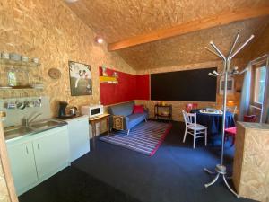a kitchen and living room with a couch and a table at La Cabane des Bains in Marciac