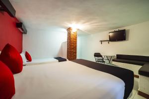 a hotel room with a bed and a tv at Capital O Hotel Meson Del Rio, Tepotzotlan in Tepotzotlán