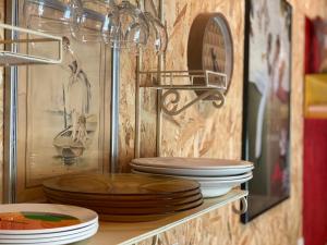 a shelf filled with plates and bowls on a wall at La Cabane des Bains in Marciac