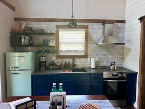 a kitchen with blue cabinets and a green refrigerator at By the Docks Knox in Knoxville