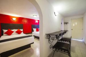 a bedroom with a bed and a red wall at Capital O Hotel Meson Del Rio, Tepotzotlan in Tepotzotlán