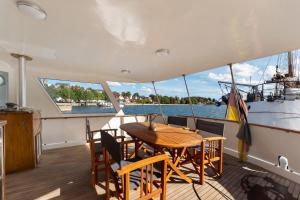 a table and chairs on the deck of a boat at Klassische Motoryacht Ocean Motion in Flensburg
