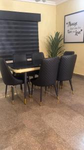 a table and chairs in a room with a plant at Max Heron, Gorgeous 2 Bedroom in Ikeja