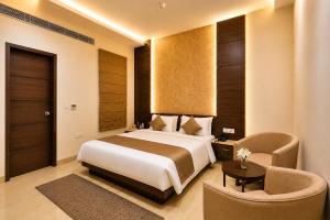 a bedroom with a bed and a table and chairs at Hotel Paarth in Ludhiana