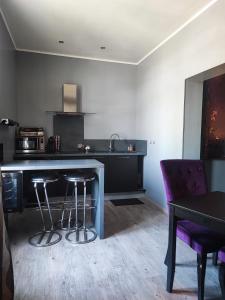 a kitchen with a counter and a table and chairs at Appartement tout confort avec balnéo et lit king size in Pézenas +11 photos