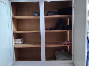 a cupboard with wooden shelves in a room at Weerribben Wieden gastenverblijf in Wanneperveen