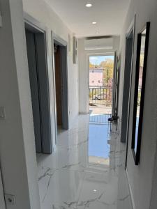 a hallway with marble flooring in a house at Apartmani Rubi 2 in Herceg-Novi