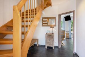 a staircase in a living room with a table and a mirror at Haus Am Dorfteich B eingefriedet in Fehmarn