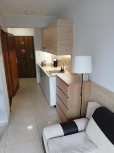 a small kitchen with a couch and a table at Apartament 112 Mielno in Mielno +1 photo