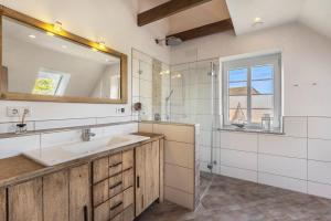 a bathroom with a sink and a mirror at Haus Am Dorfteich B eingefriedet in Fehmarn +27 photos
