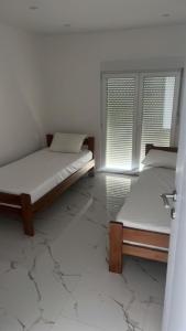 a bedroom with two beds and a window at Apartmani Rubi 2 in Herceg-Novi +17 photos