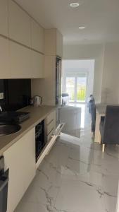 a kitchen with white cabinets and a counter top at Apartmani Rubi 2 in Herceg-Novi