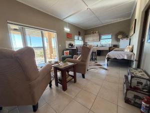 a living room with chairs and a table and a kitchen at Karibu Self-Catering unit 2 in Omaruru
