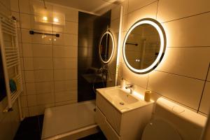 a bathroom with a toilet and a sink and a mirror at Danube Breeze Apartment in Giurgiu