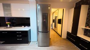 a kitchen with a stainless steel refrigerator and a hallway at Danube Breeze Apartment in Giurgiu
