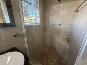 a bathroom with a shower with a toilet and a sink at Karibu Self-Catering unit 2 in Omaruru +85 photos