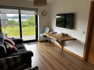 a living room with a couch and a wooden table at Achnacolain Lodge in Tarbert