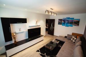 a living room with a couch and a tv at Danube Breeze Apartment in Giurgiu