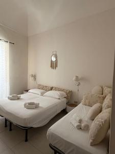 two beds in a white room with towels on them at Dimora Via Roma in San Severo