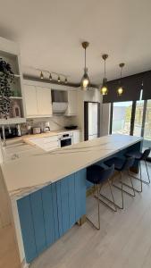 a kitchen with a blue and white counter and chairs at Beachfront Villa with private beach and pool in Bogazici