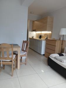 a room with a kitchen and a dining table and a kitchen at Apartament 112 Mielno in Mielno