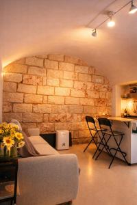 a living room with a couch and a brick wall at SalentoTraTerraMare in Diso