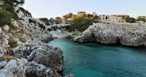 a body of water next to a rocky cliff at SalentoTraTerraMare in Diso