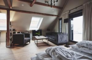a bedroom with a bed and a couch and a table at Havn Hotell og Restaurant in Skudeneshavn +31 photos