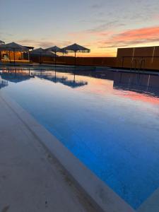 a pool of water with umbrellas on top of it at Privilege Hotel & Spa in Tirana