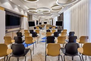 a large room with chairs and a projection screen at AC Hotel by Marriott Strasbourg in Strasbourg