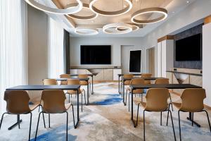 a conference room with tables and chairs and a large chandelier at AC Hotel by Marriott Strasbourg in Strasbourg