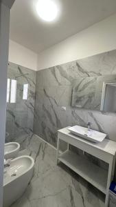 a bathroom with a sink and a toilet and a tub at Li Geusi in Torre Lapillo