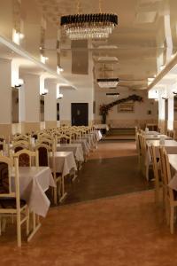 a banquet hall with white tables and chairs at Перлина Карпат in Pystanʼ