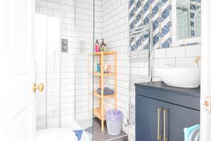 a bathroom with a blue cabinet and a sink at Charming Cottage, Lake District in Little Broughton +11 photos
