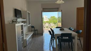 a kitchen and dining room with a table and chairs at Li Geusi in Torre Lapillo +15 photos