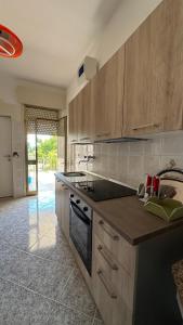 a kitchen with wooden cabinets and a stove top oven at Li Geusi in Torre Lapillo