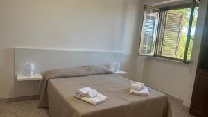 a bedroom with a bed with towels on it at Li Geusi in Torre Lapillo