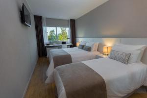 ein Hotelzimmer mit zwei Betten und einem Fenster in der Unterkunft Hotel Flores in Trinidad