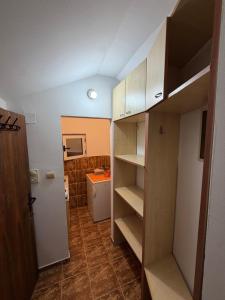 a small room with a closet and a refrigerator at ADM Apartment in Bečići