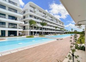 an external view of a large apartment building with a swimming pool at Cana Rock Infinity Pool & Beach Club in Punta Cana