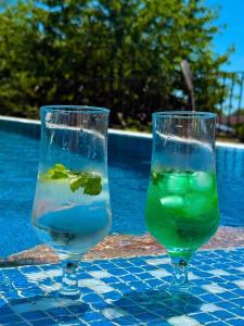 two glasses of water on a table next to a pool at Sea Garden Escape - Byala in Byala