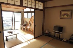 a living room with a sliding glass door and a television at Fukumakan in Matsue