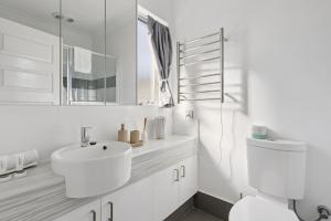 a white bathroom with a sink and a toilet at The Aveley Retreat in The Vines +19 photos